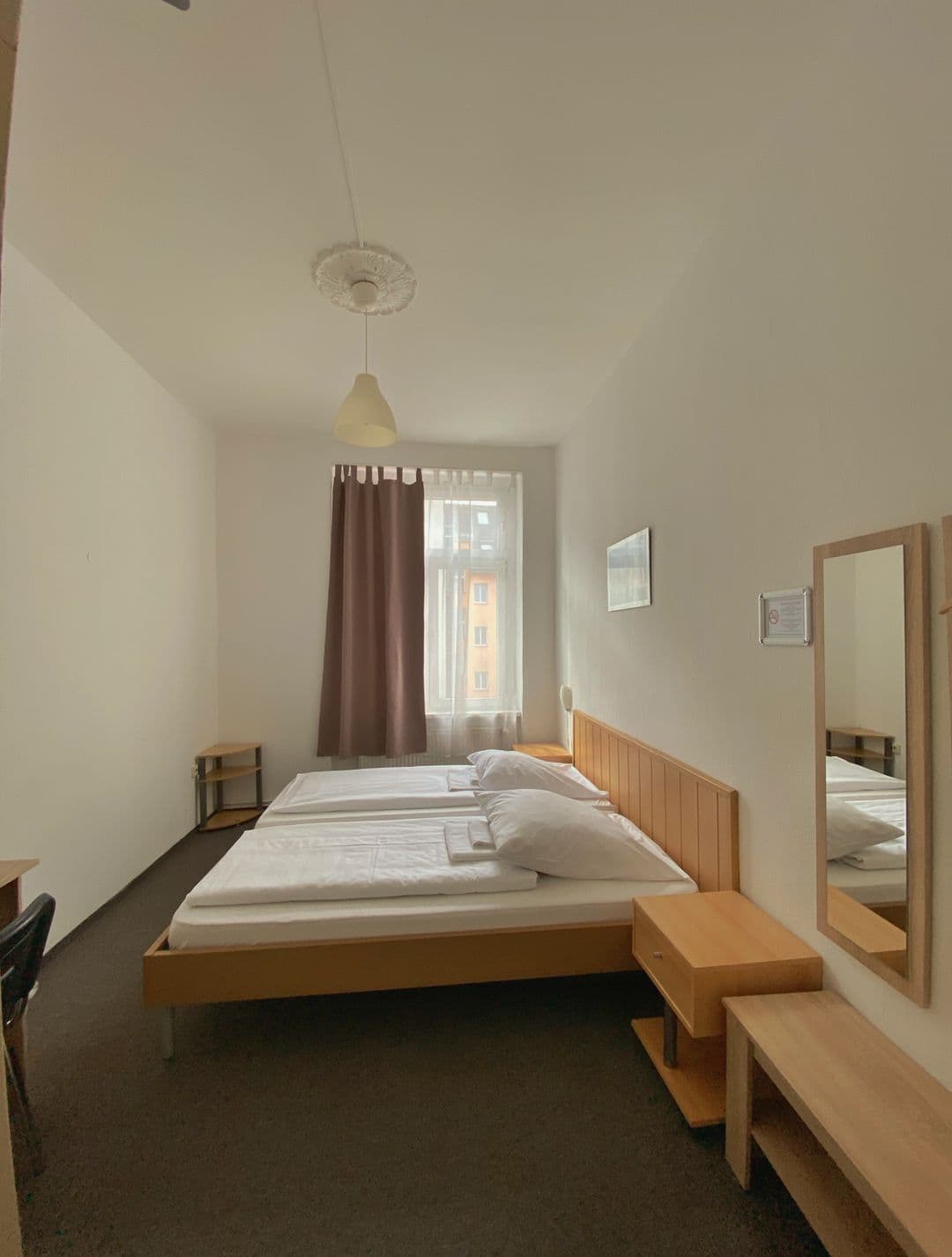 Doppelzimmer Economy mit Doppelbett aus Holz und Nachttisch