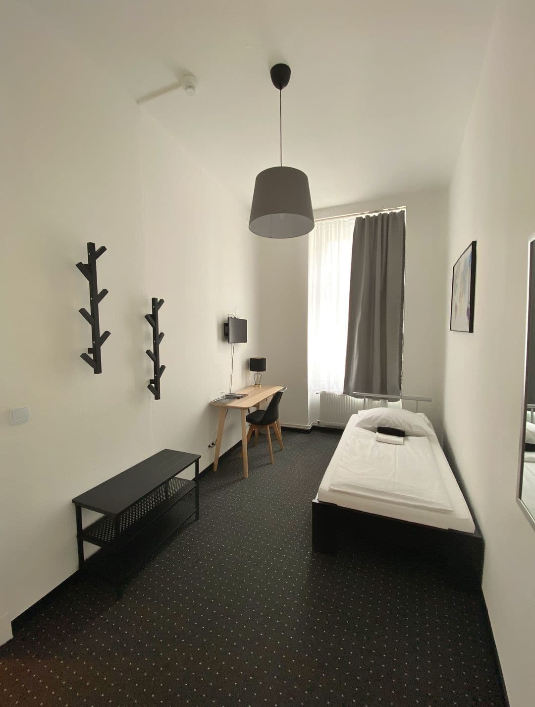 Einzelzimmer mit Einzelbett, Schreibtisch und Garderobe