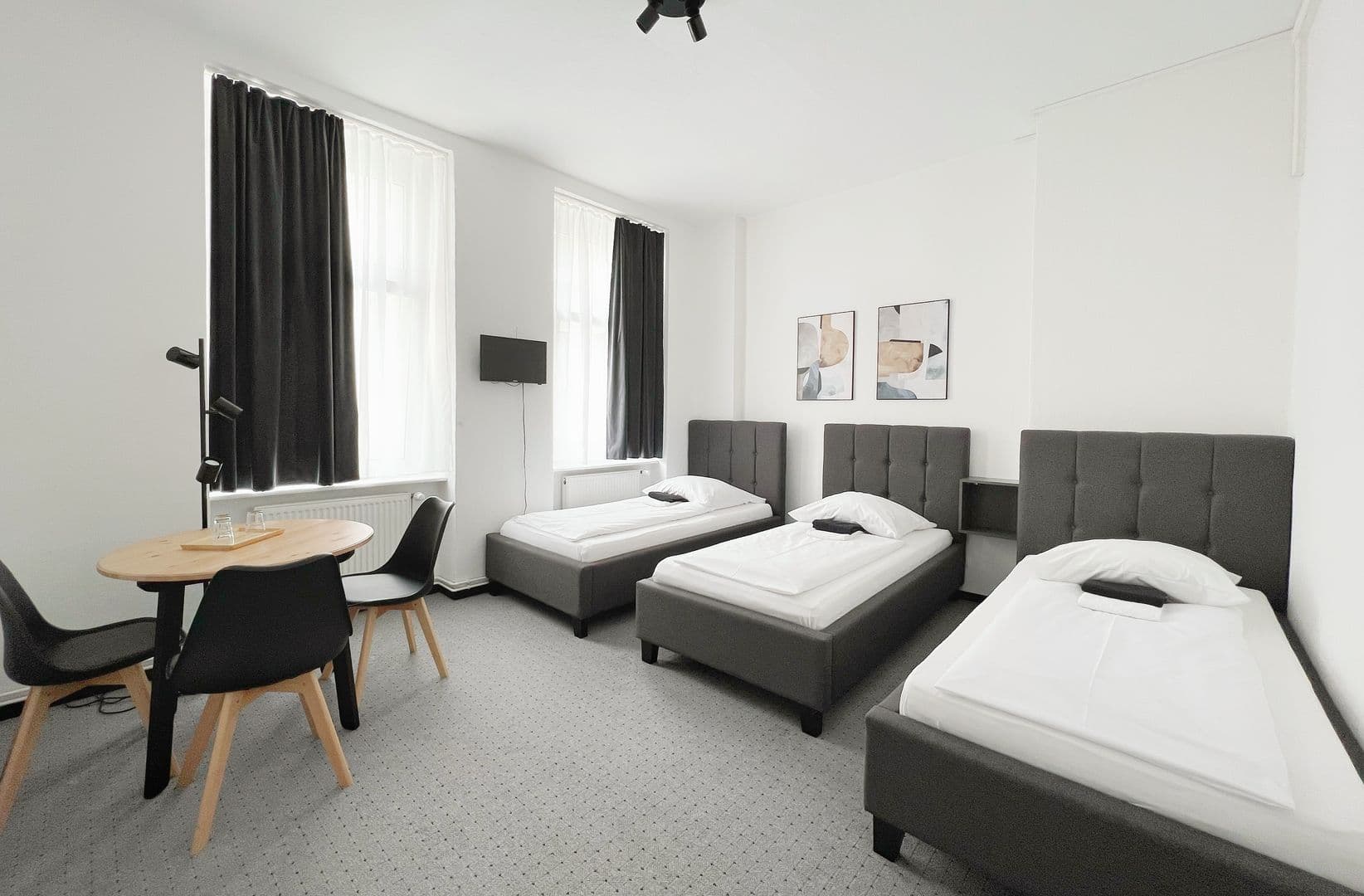 Dreibettzimmer Standard mit Sitzgruppe und drei Betten